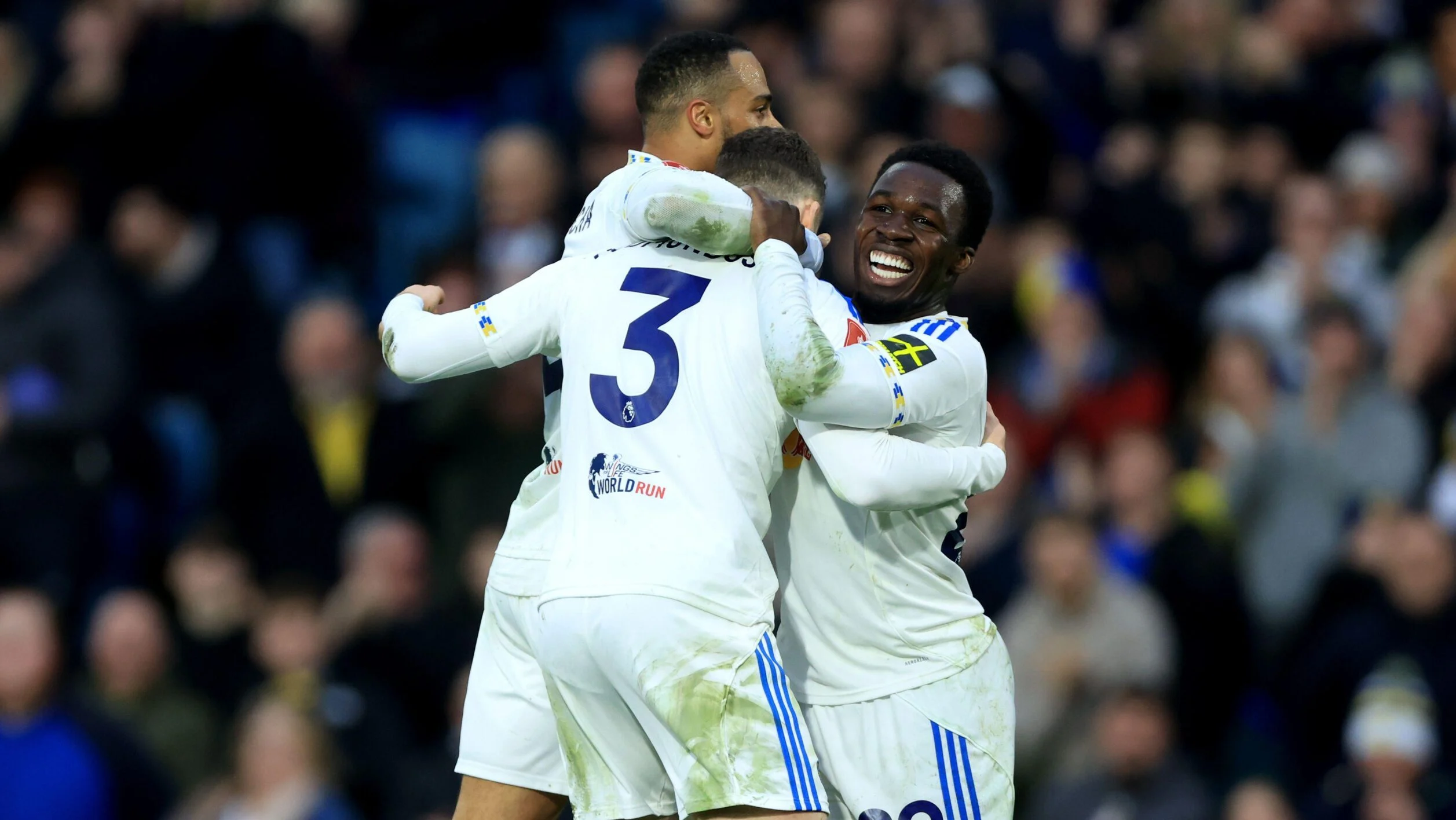 Gabriel Gudmundsson, Wilf Gnonto and Lukas Nmecha have a group hug as they celebrate Leeds United's 3-0 win against Norwich City.