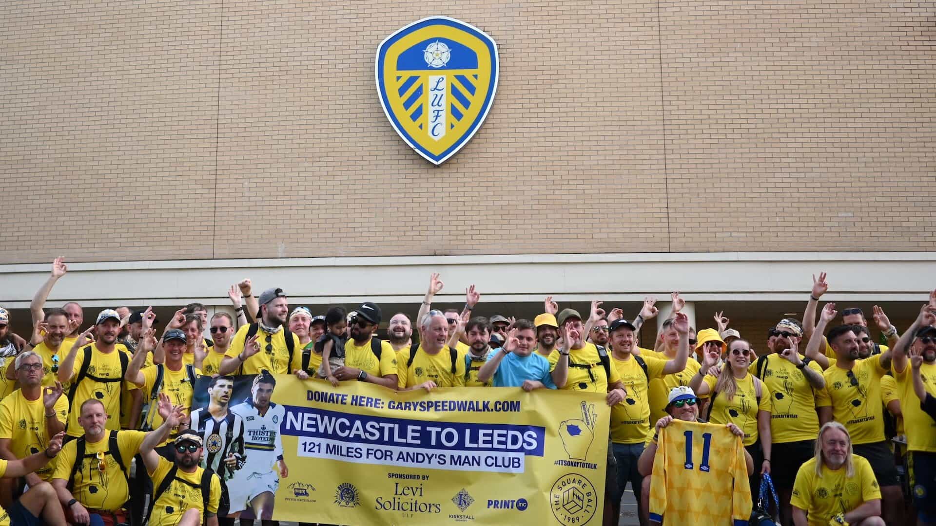 Our very tired but relieved walkers pose for a photo back at Elland Road in front of the East Stand