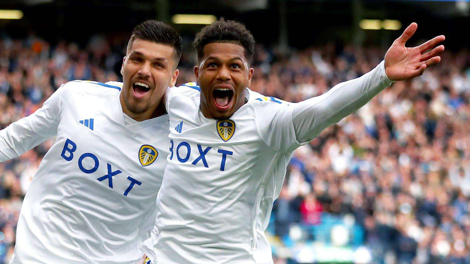 Joel Piroe and Georginio Rutter celebrating a goal in front of the camera, Piroe looking down the lens, Rutter shouting with his arm outstretched