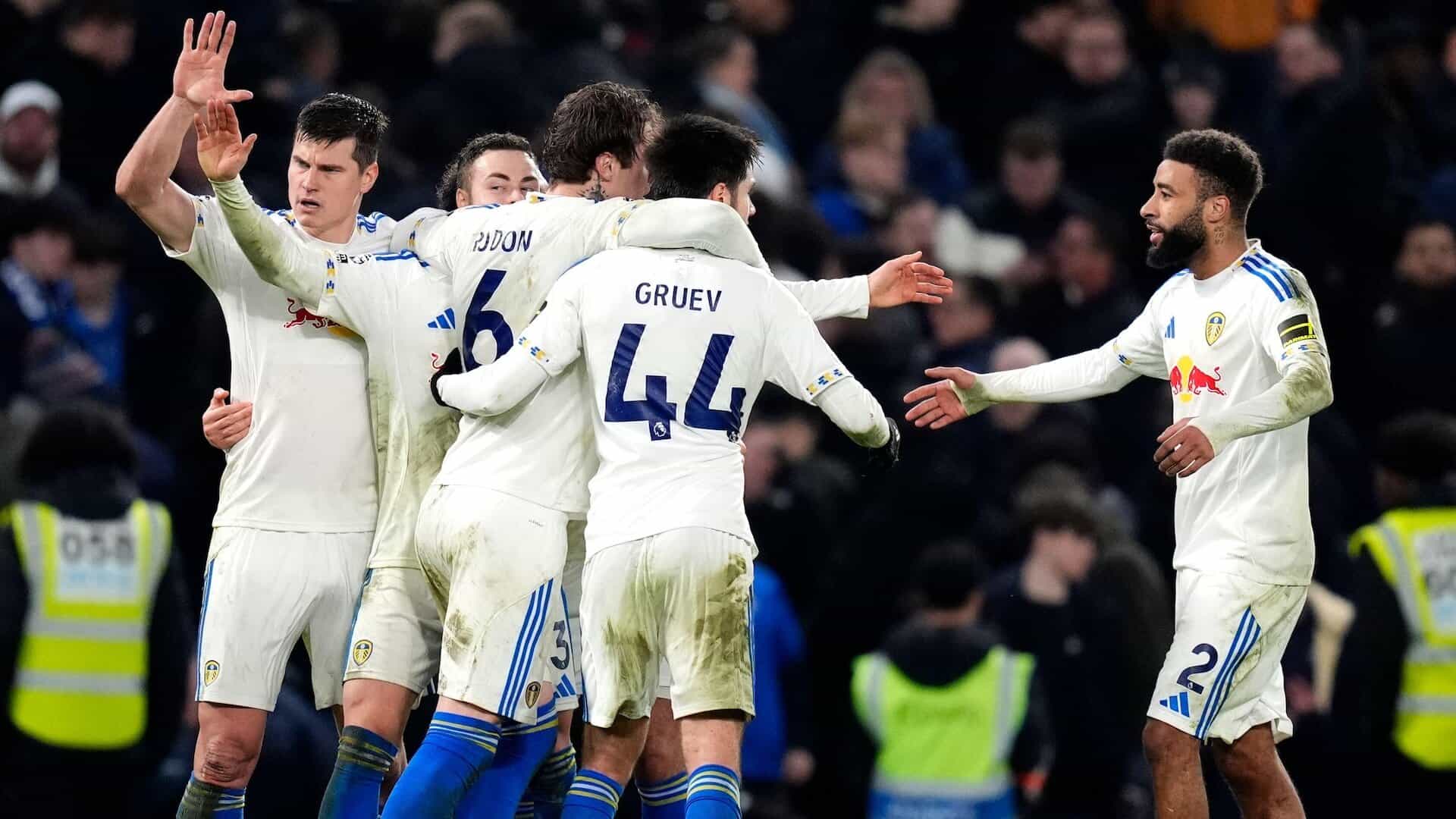 Jayden Bogle joins the Leeds defence hugging at full-time celebrating the 2-2 draw at Chelsea