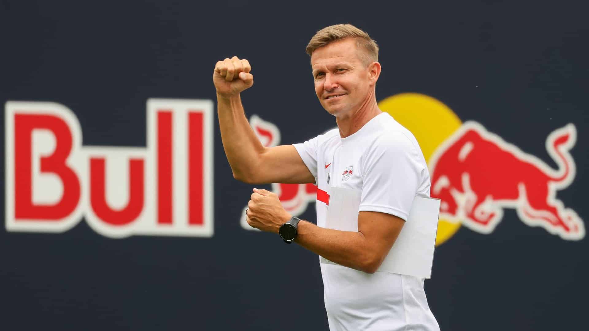 This is a photo of Jesse Marsch walking in front of a banner at the RB Academy, so it's the word 'Bull' in massive letters, then there's him giving someone a clenched fist salute
