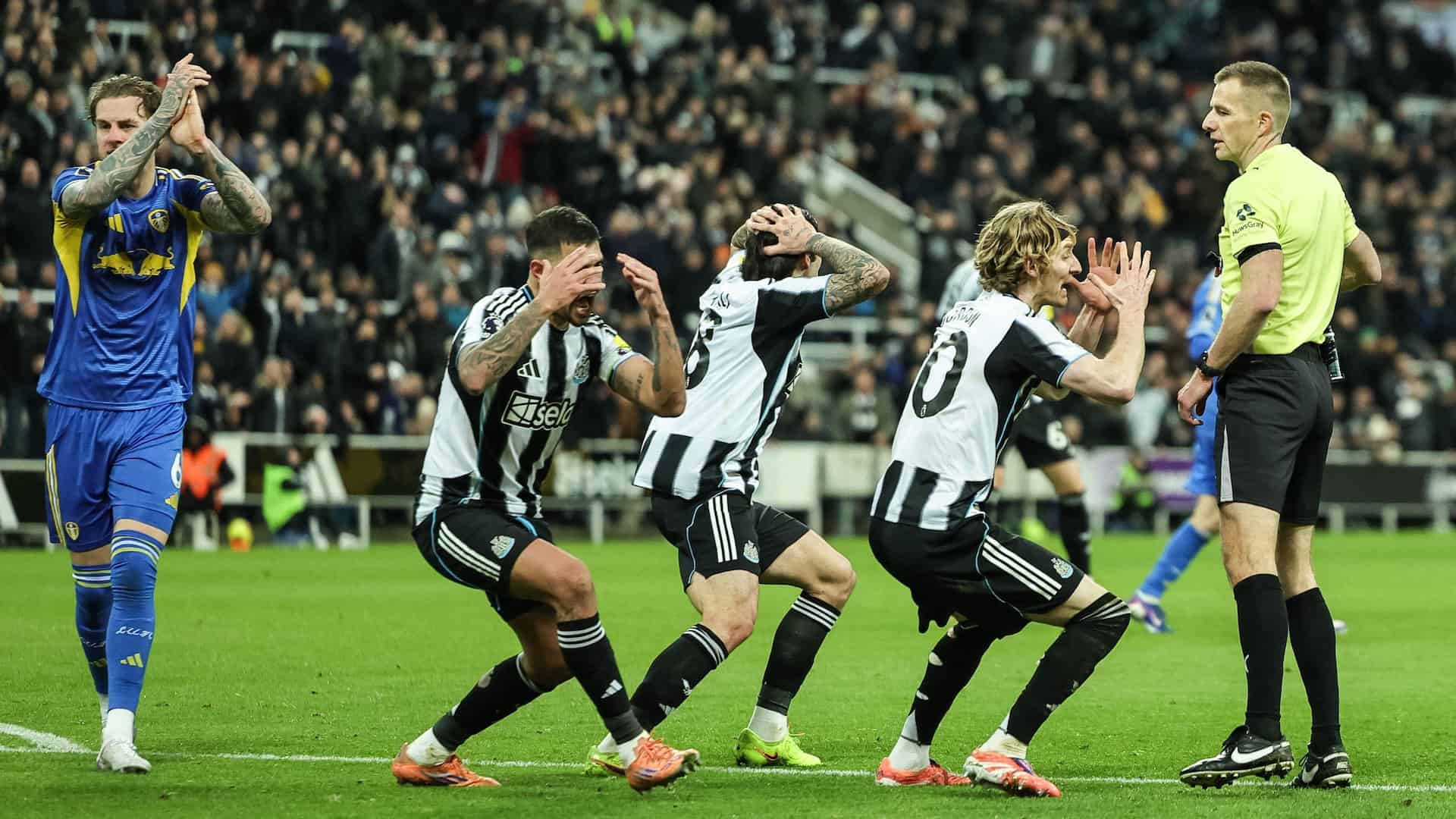 Three Newcastle cheats berate the ref as he books fellow cheat Joelinton for diving trying to win a penalty, Joe Rodon stands next to them applauding