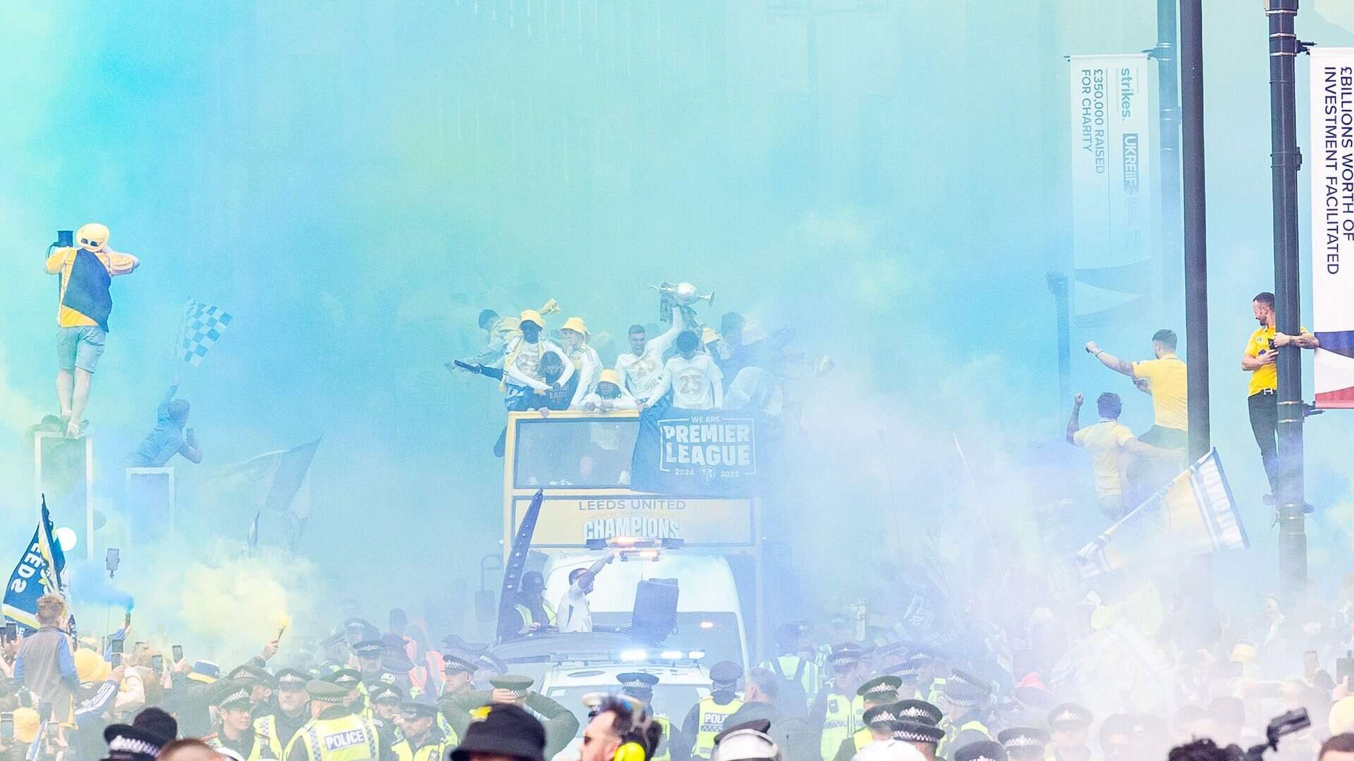 The promotion bus parade travelling slowly through Leeds city centre and a cloud of blue and yellow flares