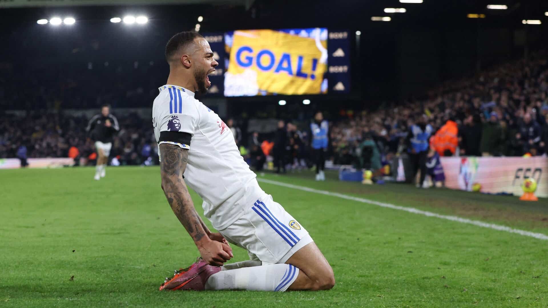 Lukas Nmecha sliding on his knees celebrating his late winner against Fulham with the scoreboard flashing in the background: "GOAL!"
