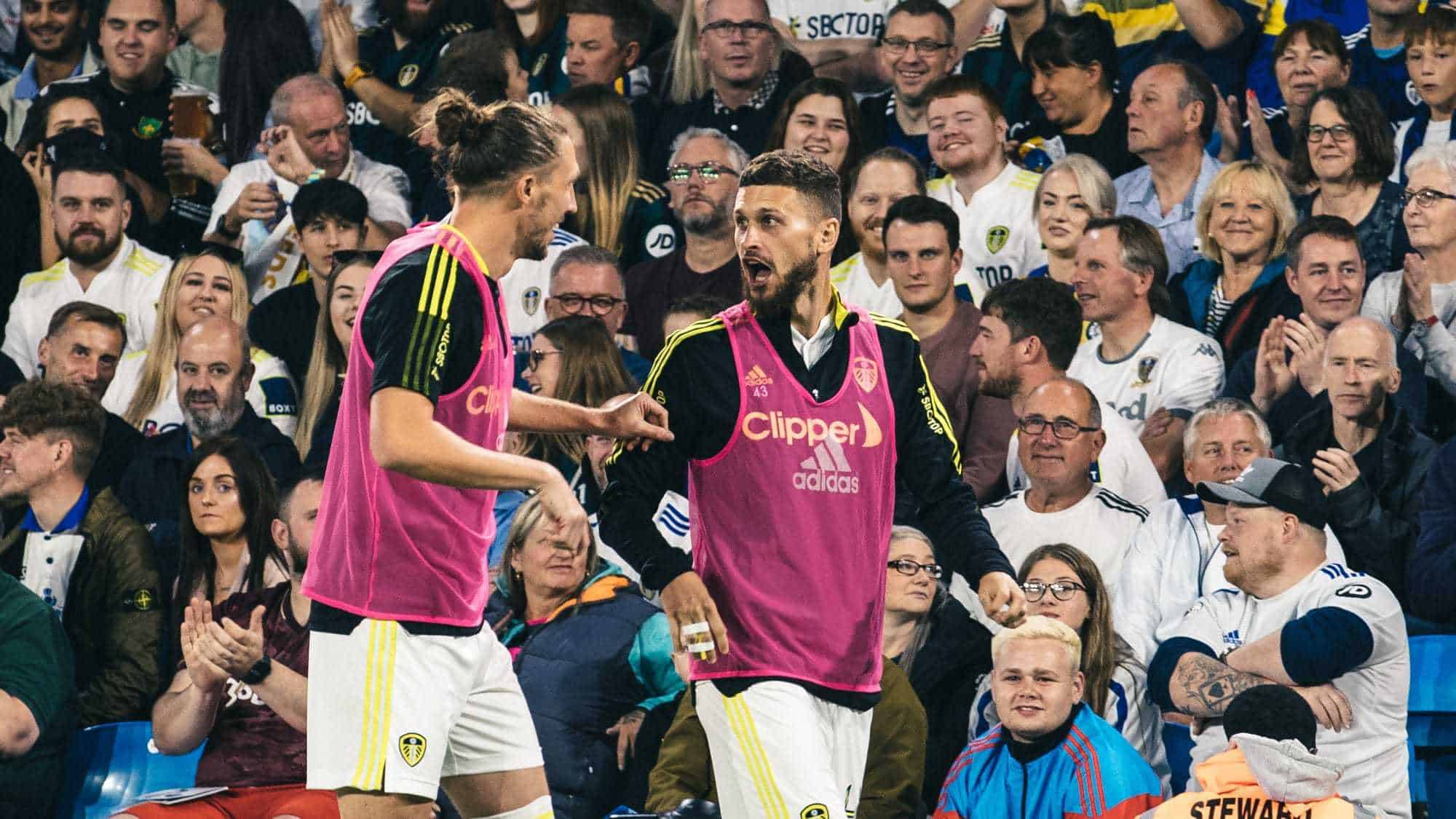Luke Ayling is telling Mateusz Klich about the attempted streaker who just ran on near where they're warming up, Klich looks very shocked