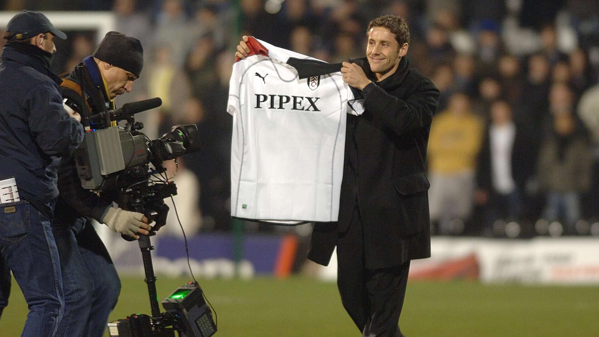 Michael Brown being unveiled as a new signing on the pitch at Fulham holding a shirt up with a daft grin across his horrible face