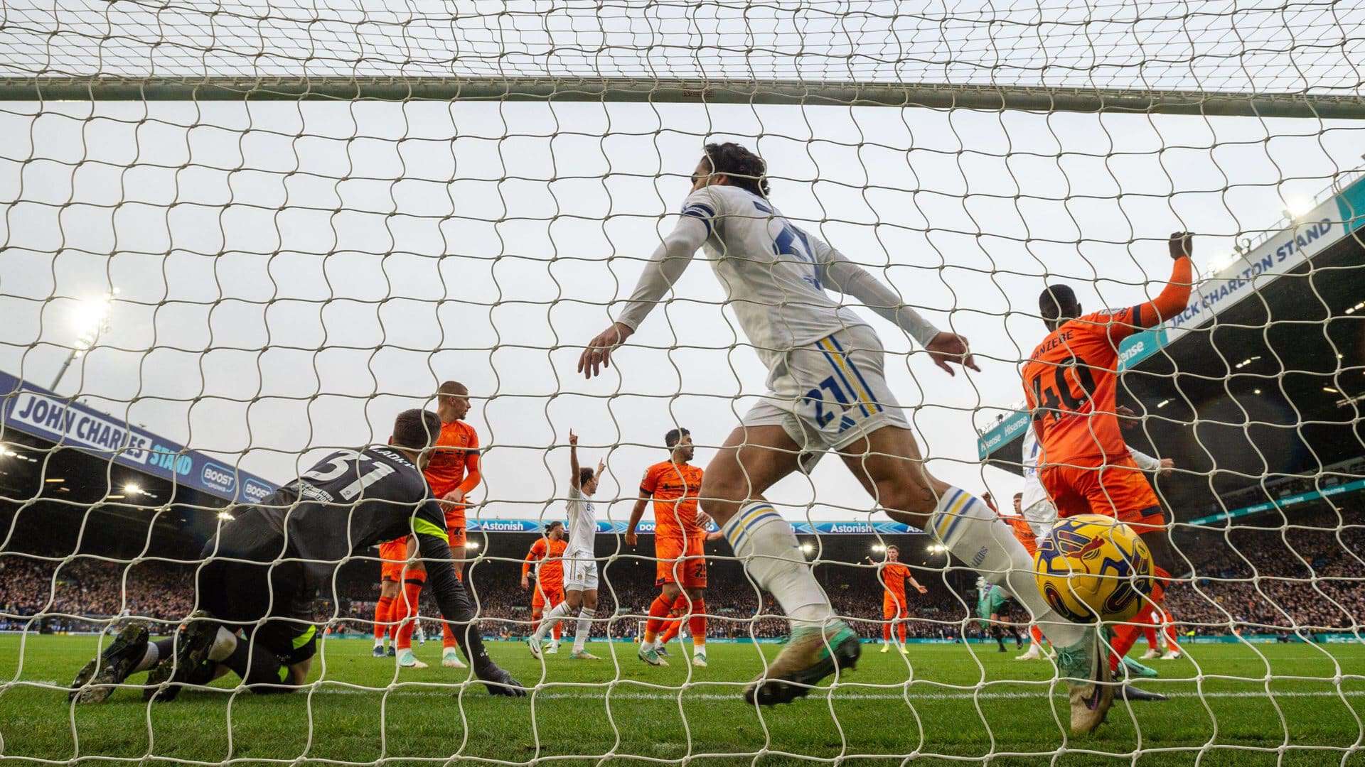 Seen from behind the net, Pascal Struijk is running through the goalmouth just after putting the ball over the line for United's first