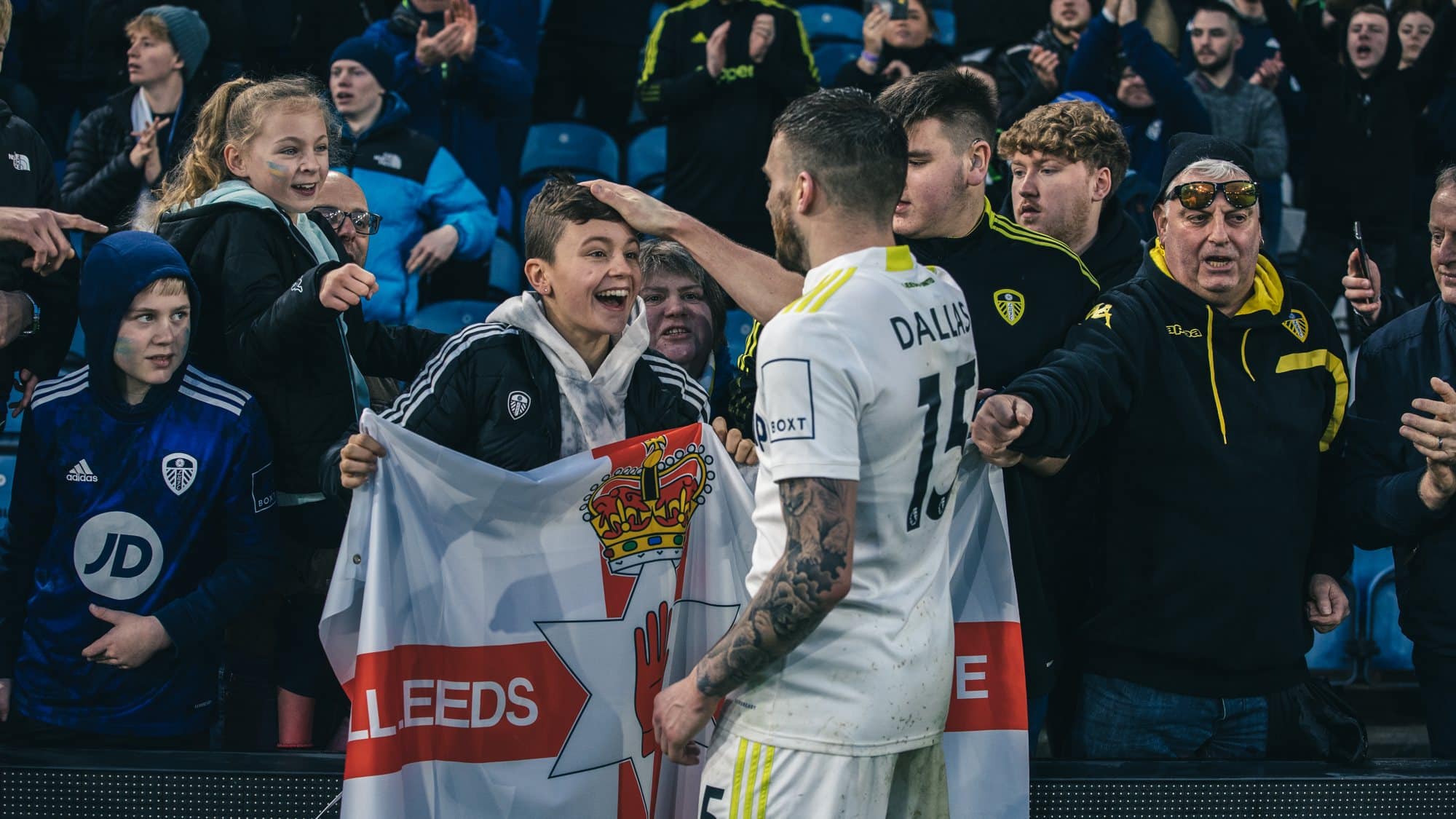 Stuart Dallas ruffles the hair of a delighted young fan after the game