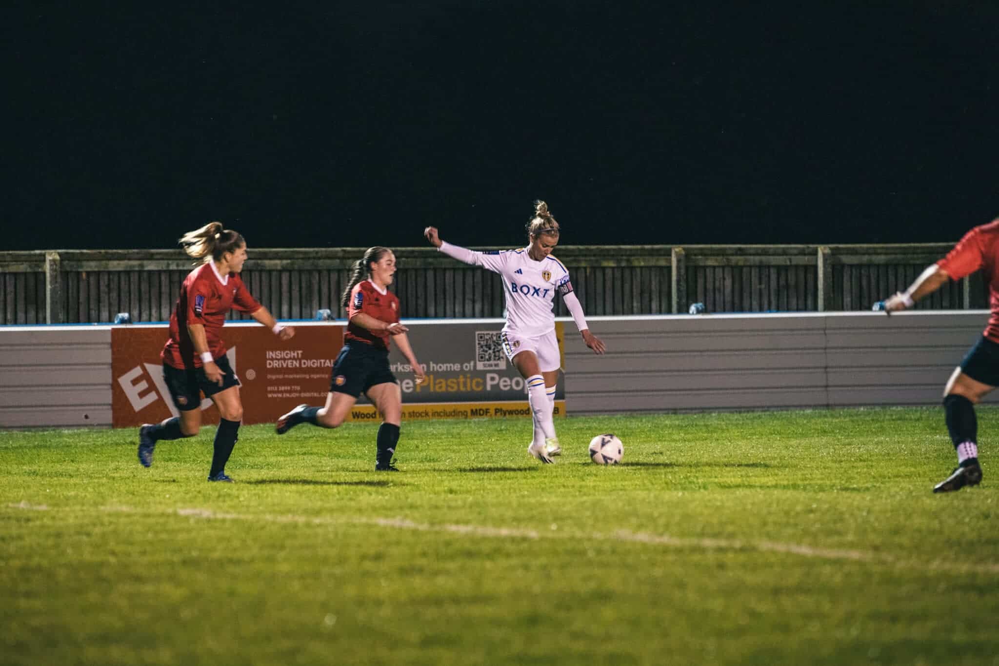 Leeds captain, friend of The Square Ball, and all-round legend Olivia Smart swinging her leg ready to strike a ball against some team in red