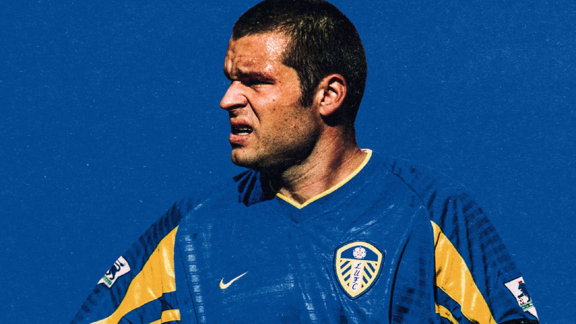Mark Viduka scowling in the blue and yellow 02/03 away shirt